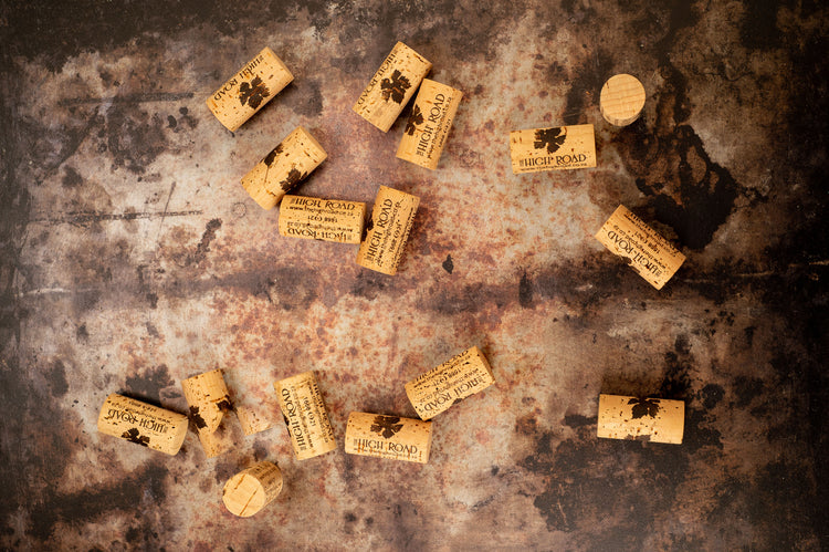 Wine corks from acclaimed The High Road wines of Stellenbosch lie on a marble surface in a flat-lay photo